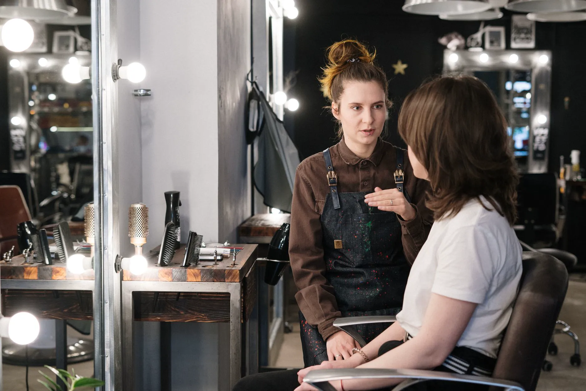 Styliste en consultation avec sa cliente dans un salon : gestion des rendez-vous professionnels